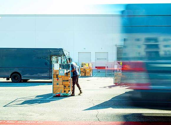Person moving a pallet at the exterior of a building | 6448